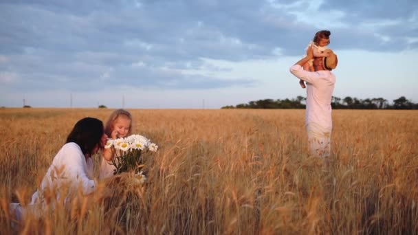 Mother and daughter smell pretty chamomile bouquet near dad — Stock Video