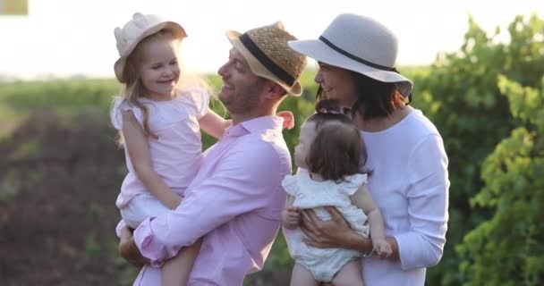 Rodzice w ładnych kapeluszach bawić się z uroczymi córeczkami — Wideo stockowe