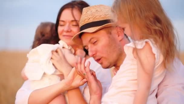 Мужчина в соломенной шляпе целует брюнетку жена держит за руку дочерей — стоковое видео