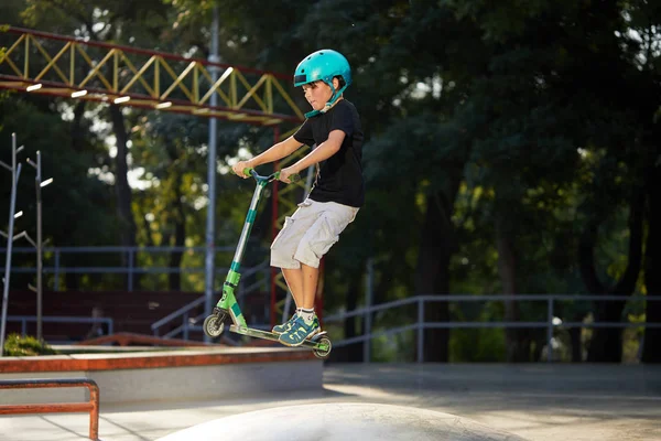 스쿠터와 헬멧에 소년은 스케이트 공원에서 놀라운 묘기를 극단적 건강한 라이프 — 스톡 사진