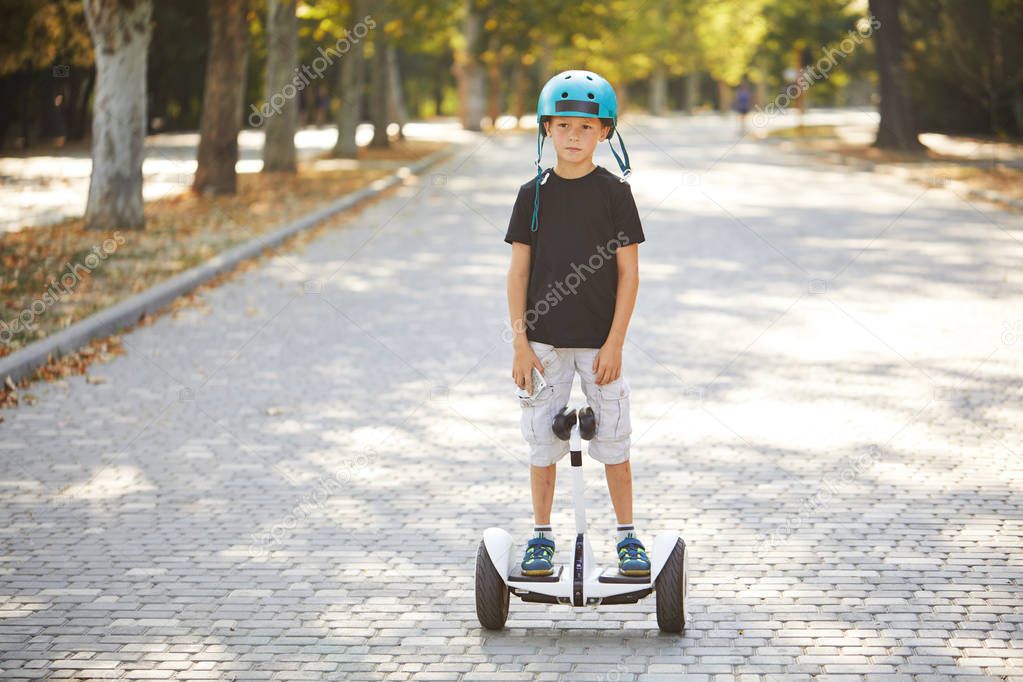 A boy riding a gyroboard in the park, a self-balancing scooter. Active lifestyle technology future.