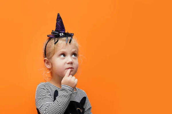 Feliz Halloween Lindo Disfraz Bruja Pensativo Sobre Fondo Naranja Mira —  Fotos de Stock