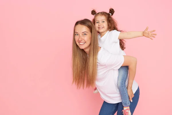 Mam Dochter Witte Shirts Jeans Spelen Knuffelen Een Roze Achtergrond — Stockfoto