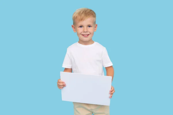 Ein Niedlicher Lachender Junge Hält Ein Weißes Schild Mit Einem — Stockfoto