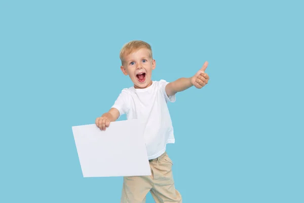 Een Schattige Lachende Jongen Houdt Een Wit Bord Vast Met — Stockfoto