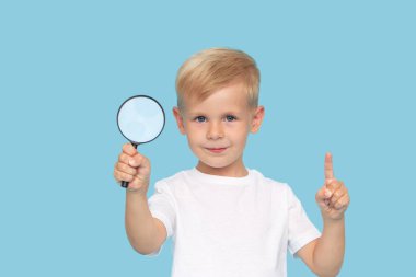 Mavi arka planda büyüteç olan sevimli çocuk. Araştırma ve keşif kavramı. 