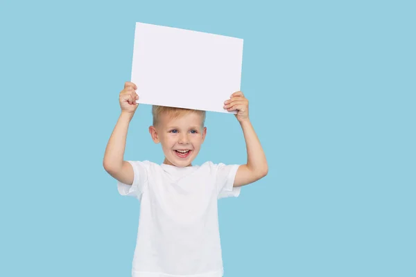 Ein Niedlicher Lachender Junge Hält Ein Weißes Schild Mit Einem — Stockfoto