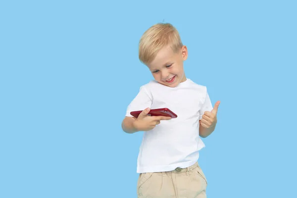 Cute Uśmiechnięty Chłopiec Smartfonem Niebieskim Tle Reklama Aplikacji Edukacyjnych Telefonie — Zdjęcie stockowe