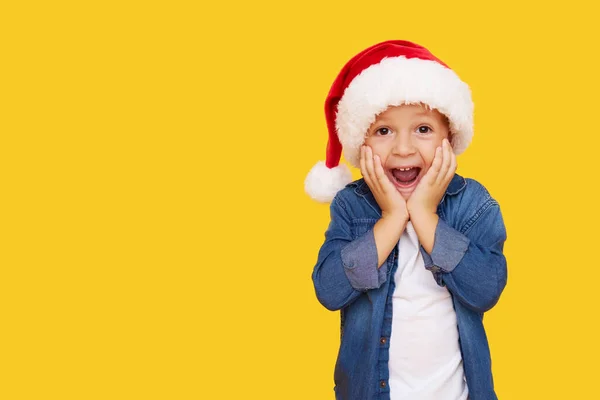 크리스마스 모자를 스러운 소년의 초상화 배경에 웃음을 있습니다 얼굴이네 — 스톡 사진