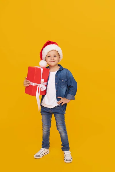 크리스마스 모자를 스러운 아이의 소리가 노란색 울려퍼졌습니다 상자를 숨긴다 휴일을 — 스톡 사진