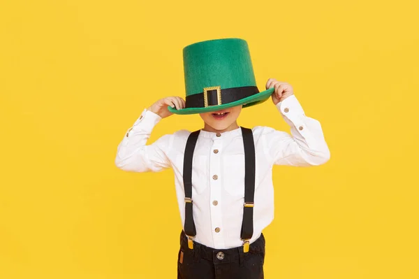 黄色の背景に緑のLeprechown帽子で小さな子供の男の子を笑顔 聖パトリックの日のお祝い 面白い顔だ — ストック写真