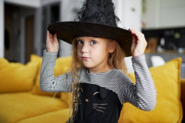 Cadı Canival kostümü giymiş komik kız çocuğu. Karantina zamanında Cadılar Bayramı tatili. Ev yapımı.