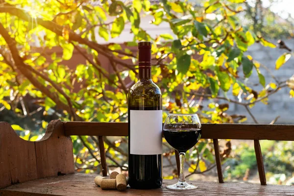 kırmızı şarap şişesi ve şarap kadehi yün fıçıda.