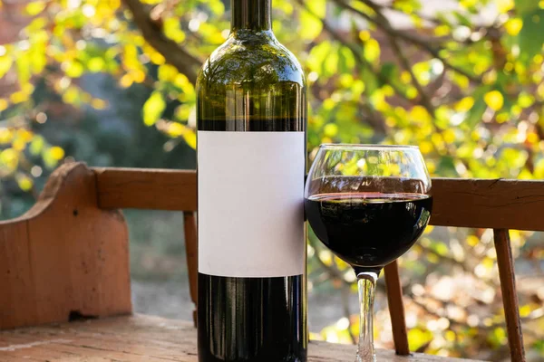 kırmızı şarap şişesi ve şarap kadehi yün fıçıda.