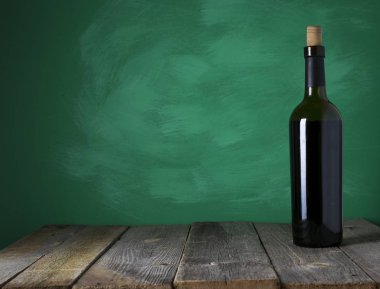 Ahşap arka planda kırmızı şarap şişesi.