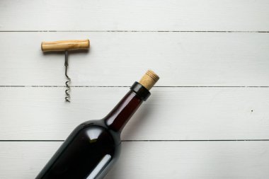 tirbuşon beyaz tahta yüzeyi ile şarap şişesi