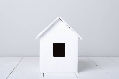 ahşap yüzeyde küçük beyaz kulübe