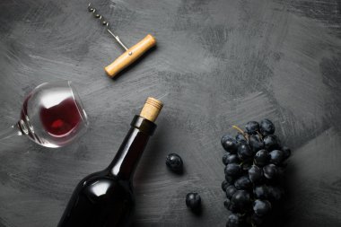 şarap cam, şişe, tirbuşon ve üzüm karanlık yüzeyi