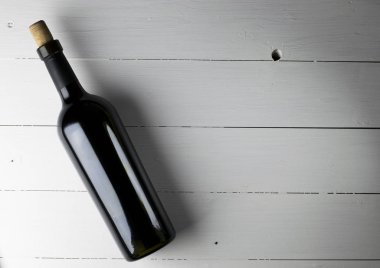 Ahşap arka planda kırmızı şarap şişesi.