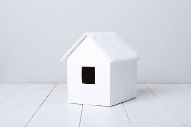 ahşap yüzeyde küçük beyaz kulübe