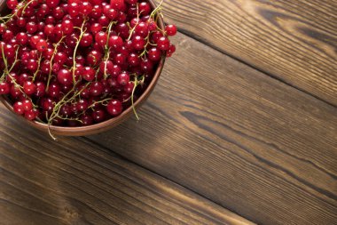 ahşap yüzey üzerinde kırmızı kuş üzümü kil kase