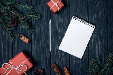 Siyah bir arka plan üzerinde Noel kompozisyon. Hediyeler, köknar ve koniler dalları.