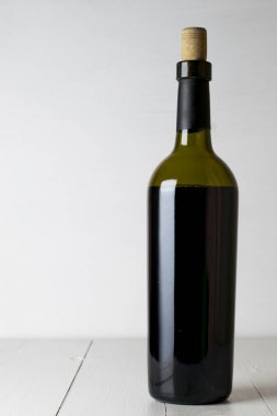 Kırmızı şarap şişesi ve tirbuşon kopya alanı Beyaz ahşap masa zemin üzerine