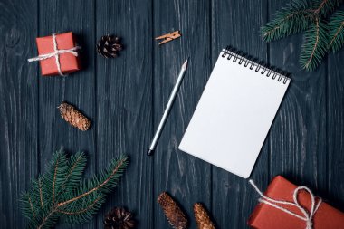 Siyah bir arka plan üzerinde Noel kompozisyon. Hediyeler, köknar ve koniler dalları.