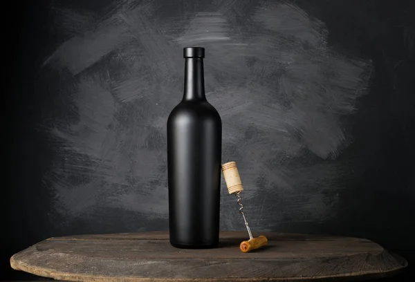 Пляшка червоного вина на дерев'яному фоні — стокове фото