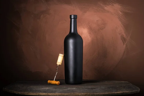 Garrafa de vinho tinto em um fundo marrom de madeira — Fotografia de Stock