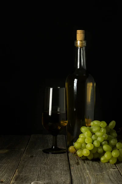Glazen fles wijn met kurken op houten tafelondergrond — Stockfoto