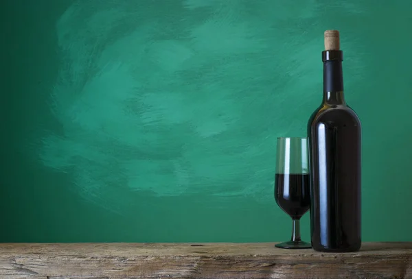 Rotweinflasche auf Holzgrund — Stockfoto