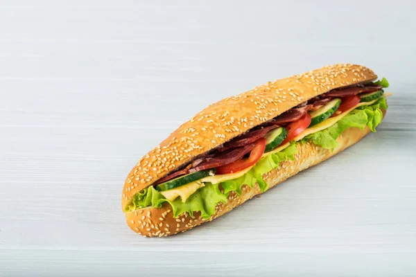 Jambon, peynir, domates, salatalık, marul ve beyaz arka plan üzerinde izole soğan taze denizaltı sandviçle