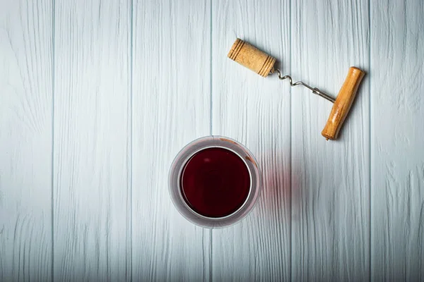Стакан красного вина на белом деревянном столе. Вид сверху — стоковое фото