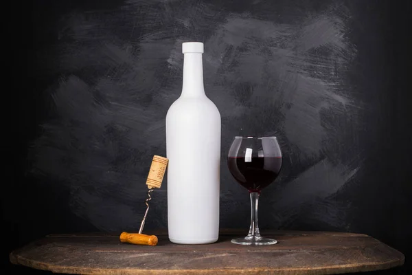 Garrafa de vinho e vidro no fundo de madeira — Fotografia de Stock