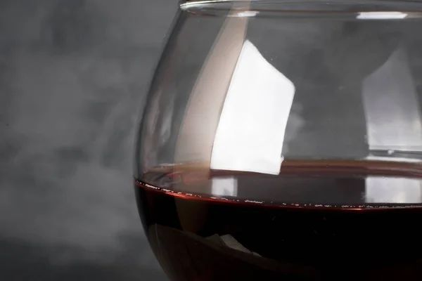 Красное вино в бокале на сером фоне — стоковое фото