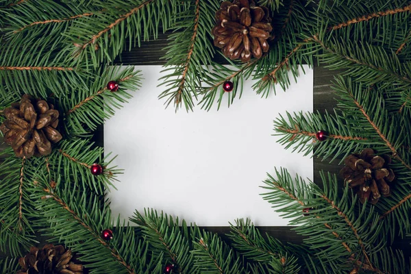 Kağıt kartla Noel ağacı dallarından yapılmış yaratıcı bir düzen. Düz yatıyordu. Doğa Yeni Yıl Konsepti.