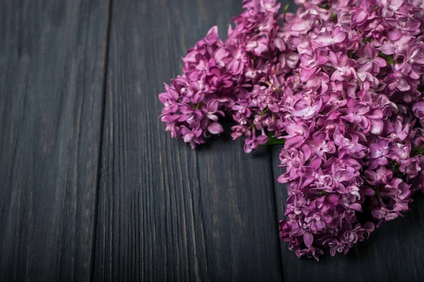 I bellissimi fiori lilla su uno sfondo di legno scuro — Foto Stock