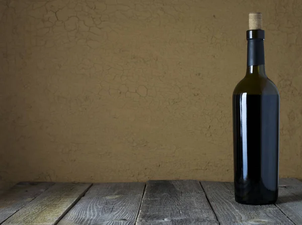 Garrafa de vinho tinto em um fundo de madeira — Fotografia de Stock