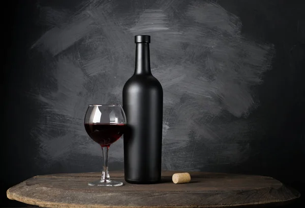 Garrafa de vinho tinto em um fundo de madeira — Fotografia de Stock