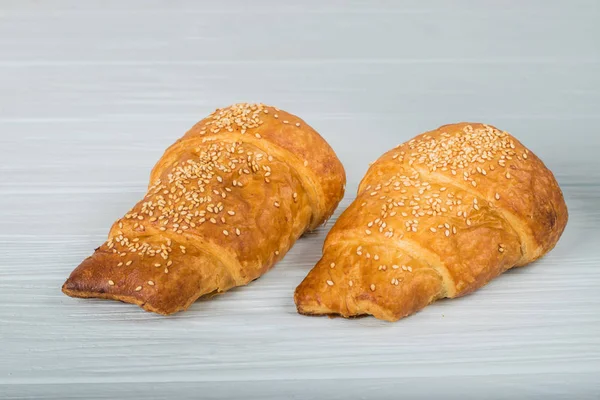 Twee croissant bestrooid met poedersuiker geïsoleerd op een witte achtergrond-closeup — Stockfoto