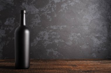 Ahşap arka planda kırmızı şarap şişesi.