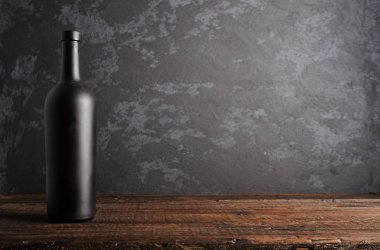 Ahşap arka planda kırmızı şarap şişesi.