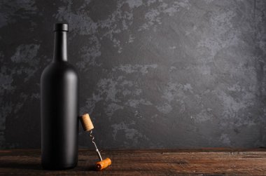 Ahşap arka planda kırmızı şarap şişesi.