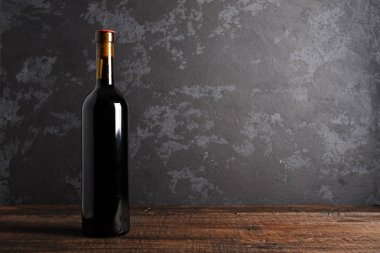 Ahşap arka planda kırmızı şarap şişesi.