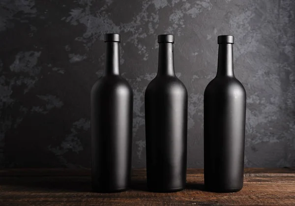 Ahşap arka planda kırmızı şarap şişesi.