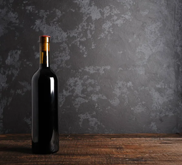 Ahşap arka planda kırmızı şarap şişesi.