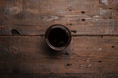 Ahşap masada bir kadeh kırmızı şarap. Yukarıdan görüntüle