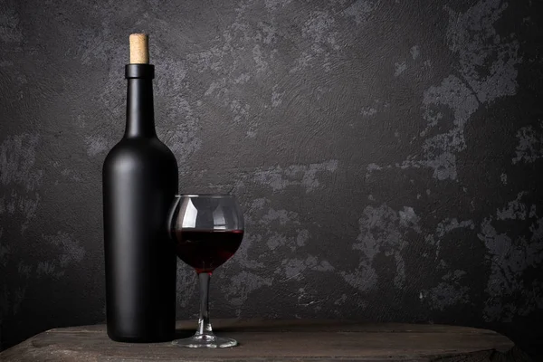 Ahşap arka planda kırmızı şarap şişesi.