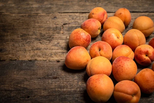 Tahta masadaki sepetin içinde taze kayısılar.